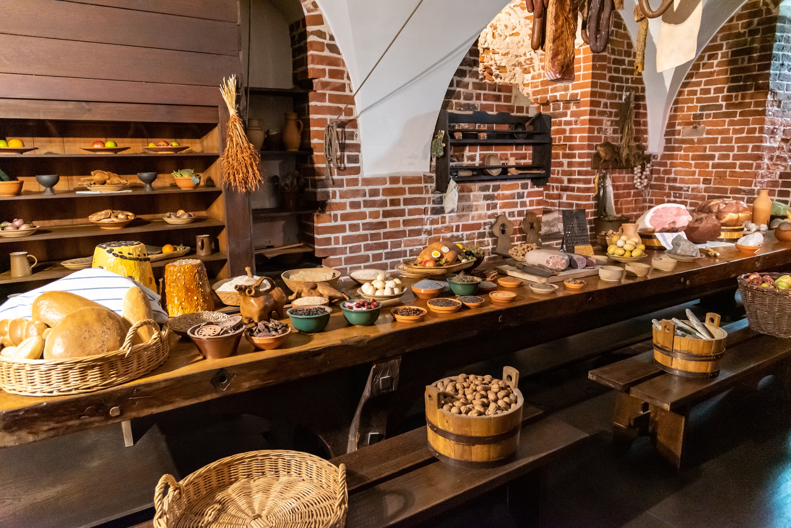 A feast of Polish food laid out on a rustic long table in an old style kitchen in a 13 century Castle of the Teutonic Order near Malbork, Poland.