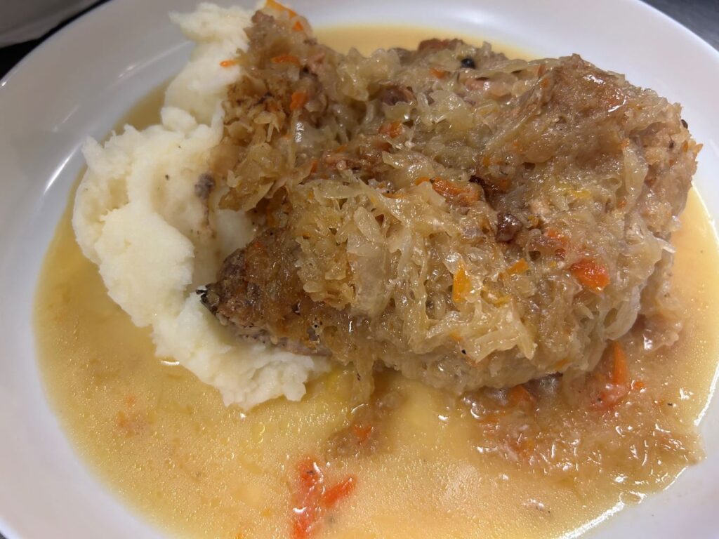 Kat's Sauerkraut and Pork Meal having tender braised pork with homemade cooked sauerkraut served with real mashed potatoes.
