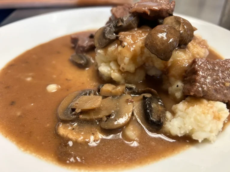 Beef stroganoff with mushrooms and rich gravy served over mashed potatoes on a white plate at Kat’s Café & Restaurant.