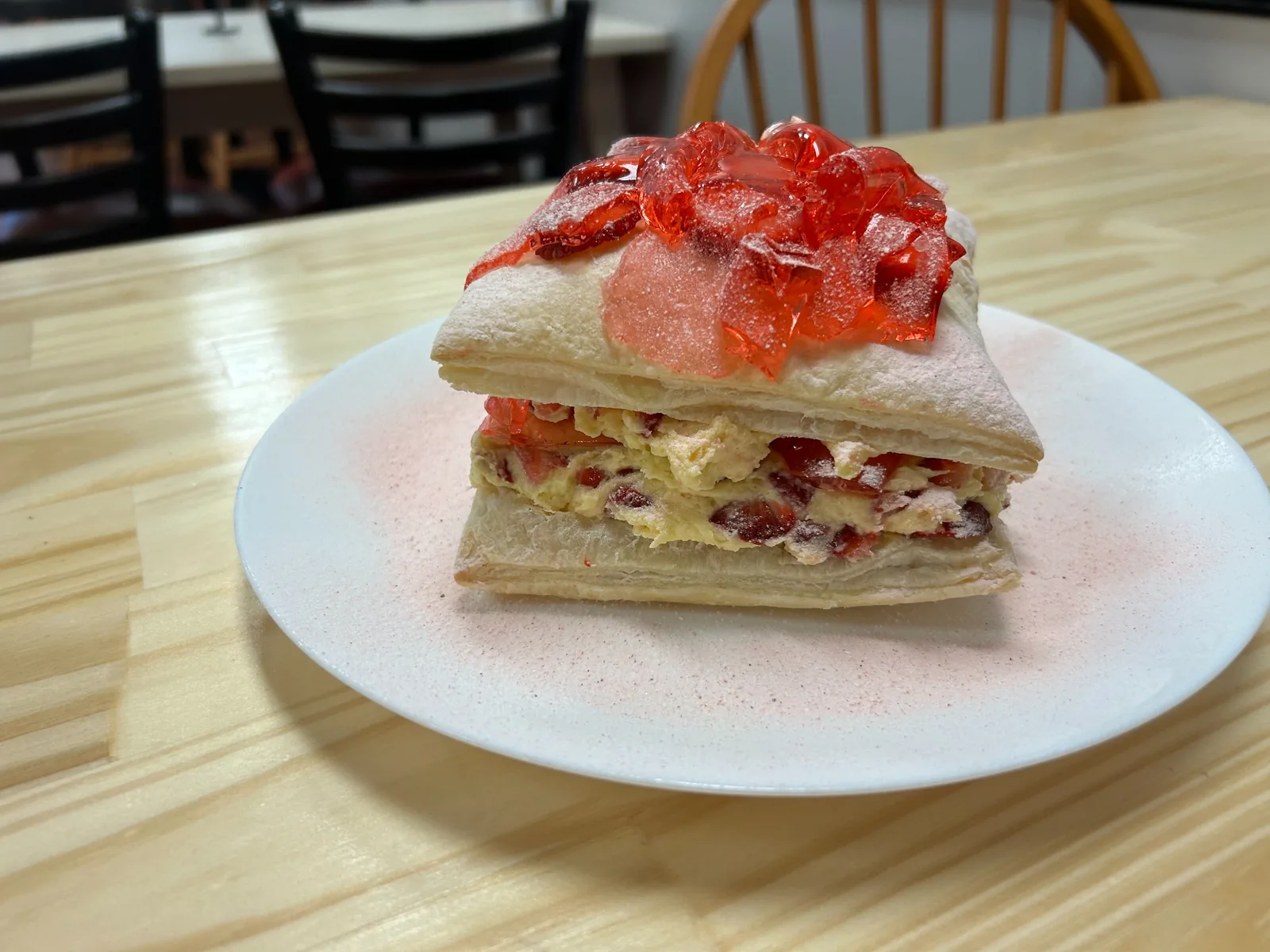Layered Napoleon pastry filled with strawberry cream and topped with a red sugar decoration at Kat’s Café & Restaurant.