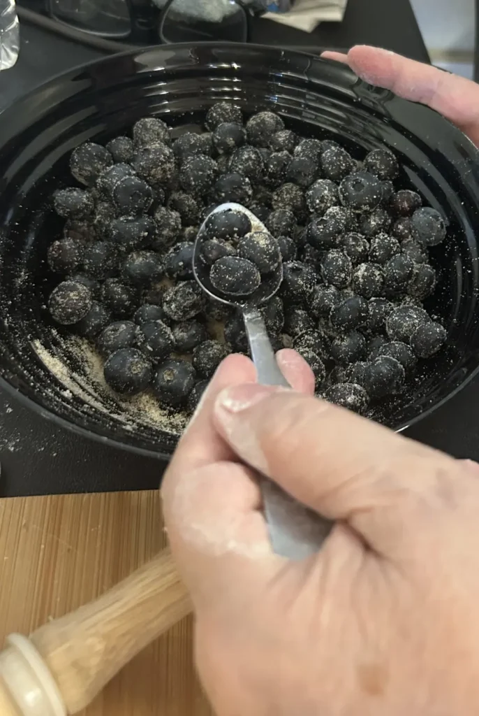 Fresh blueberries being measured from a mixing bowl while homemade blueberry pierogi filling is prepared in the kitchen at Kat’s Café & Restaurant.