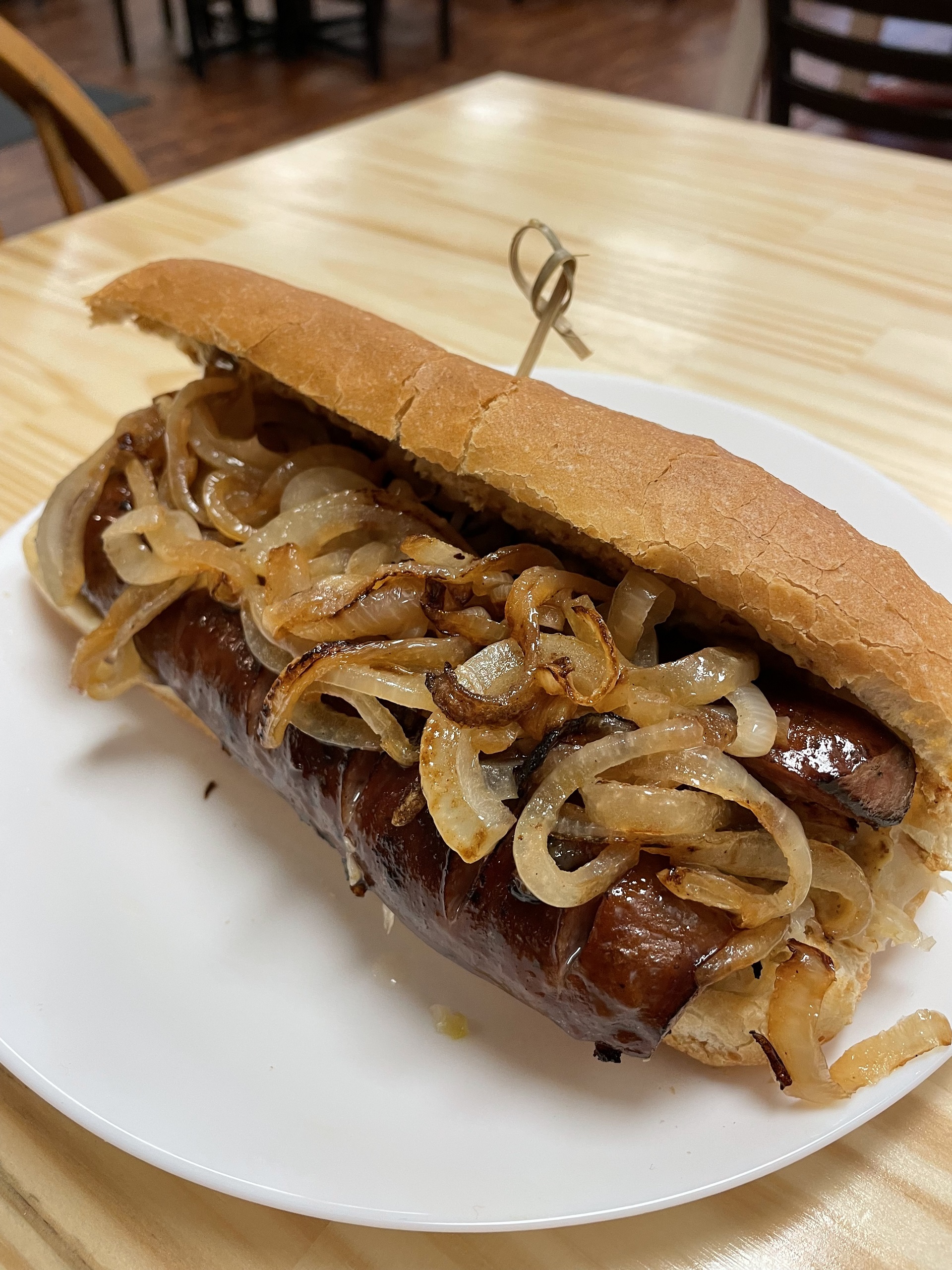 Kat's Polish Fried Kielbasa with Onions Hoagie on a white plate served on an ash wood table at the cafe-restaurant in Minersville, Pennsylvania.