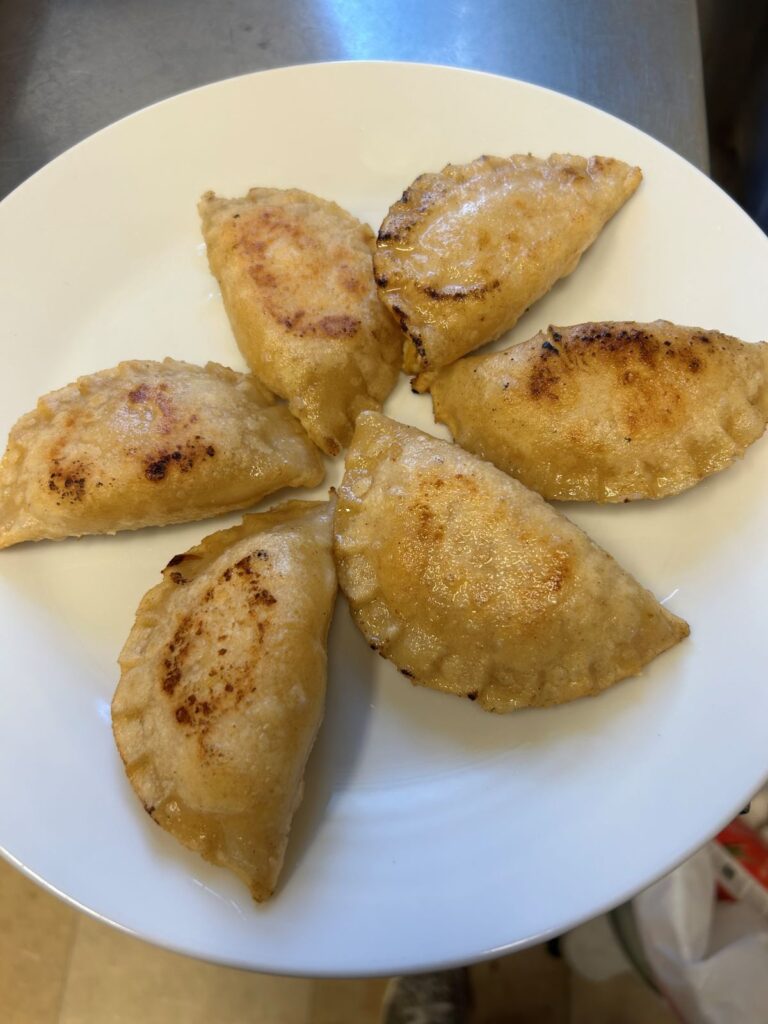 Pan-Fried Peach Pierogies on a White Plate.
