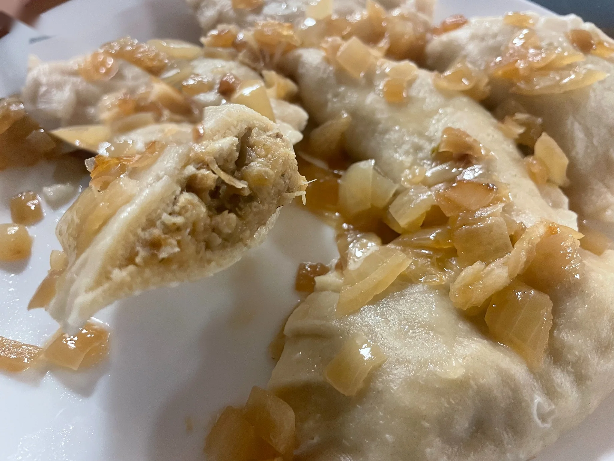 Cabbage and mushroom pierogies topped with caramelized onions, including one cut open to show the filling, at Kat’s Café & Restaurant.