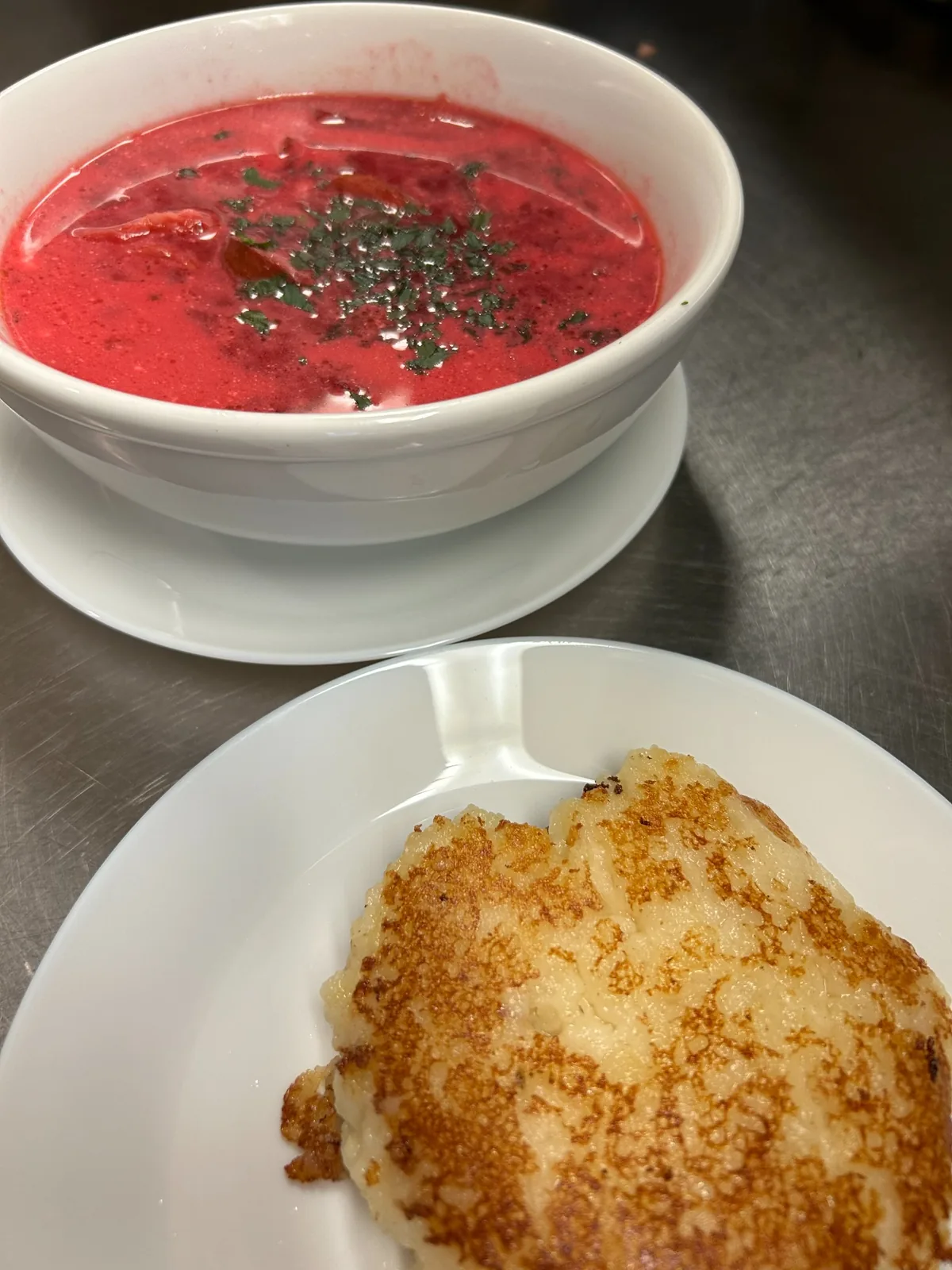 Creamy red beet borscht with smoked kielbasa and chopped herbs, served with a pan-fried mashed potato cake at Kat’s Café & Restaurant.