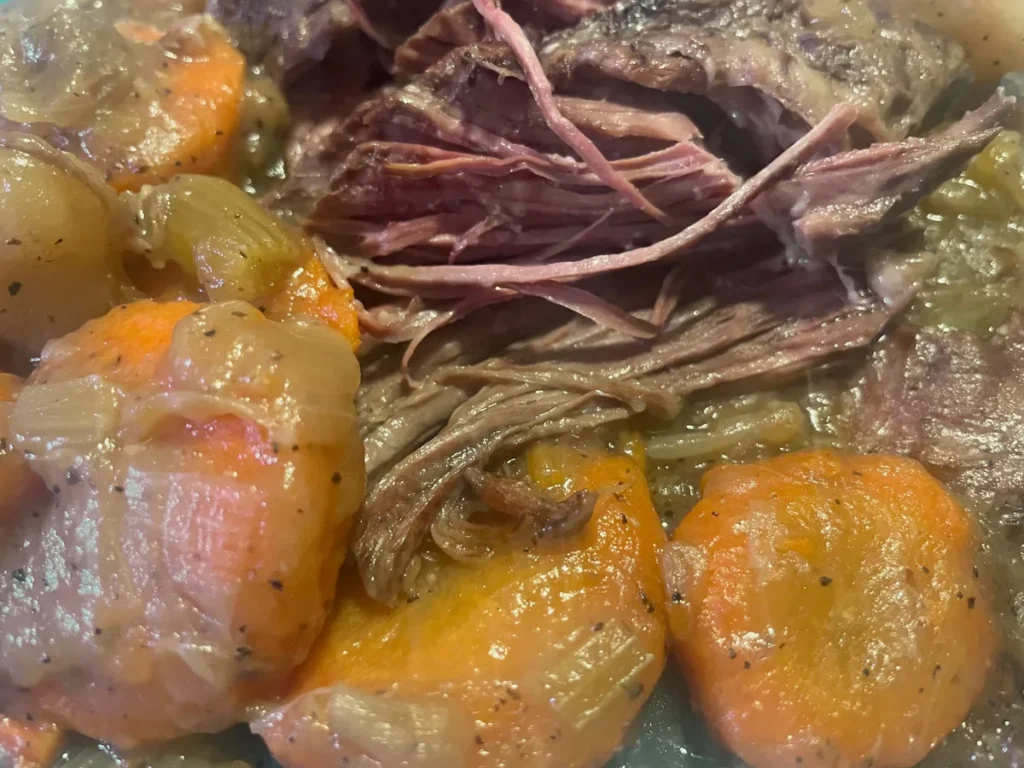 Close-up of Kat’s slow-roasted beef pot roast with carrots and onions in the cooking juices.