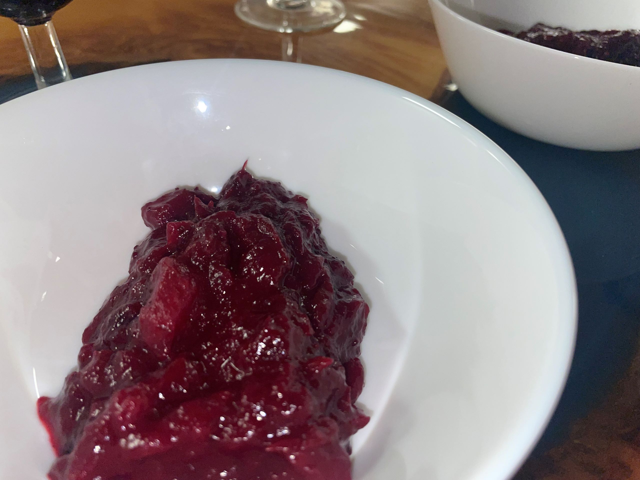 Kat's Thanksgiving Real Cranberry Sauce having chunks of fresh fruit in it served in a small white bowl.