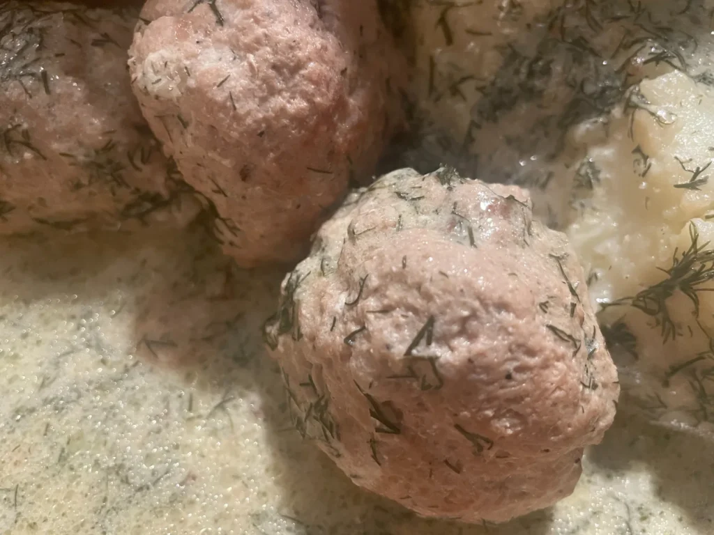 Close-up of meatballs in a creamy dill sauce with fresh dill at Kat’s Café & Restaurant.
