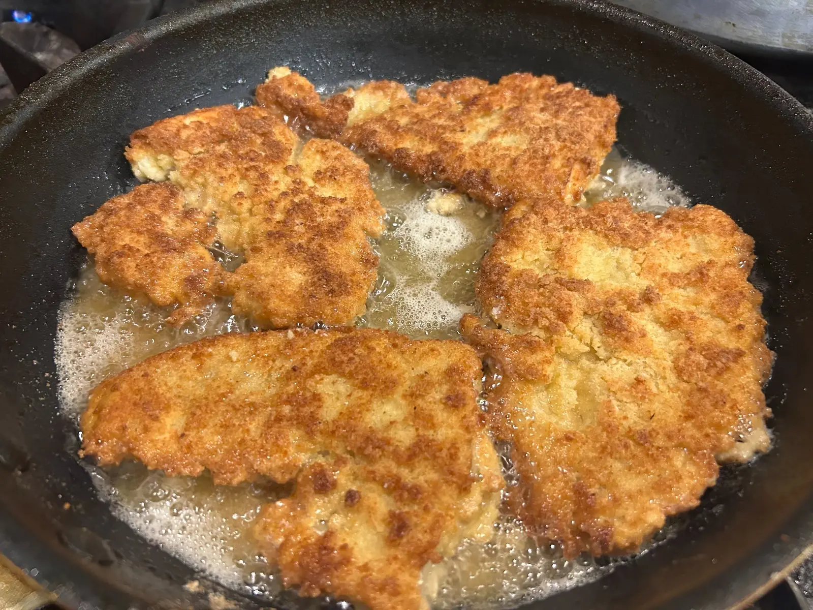Lightly breaded fish fillets pan-frying until golden in a skillet at Kat’s Café & Restaurant.