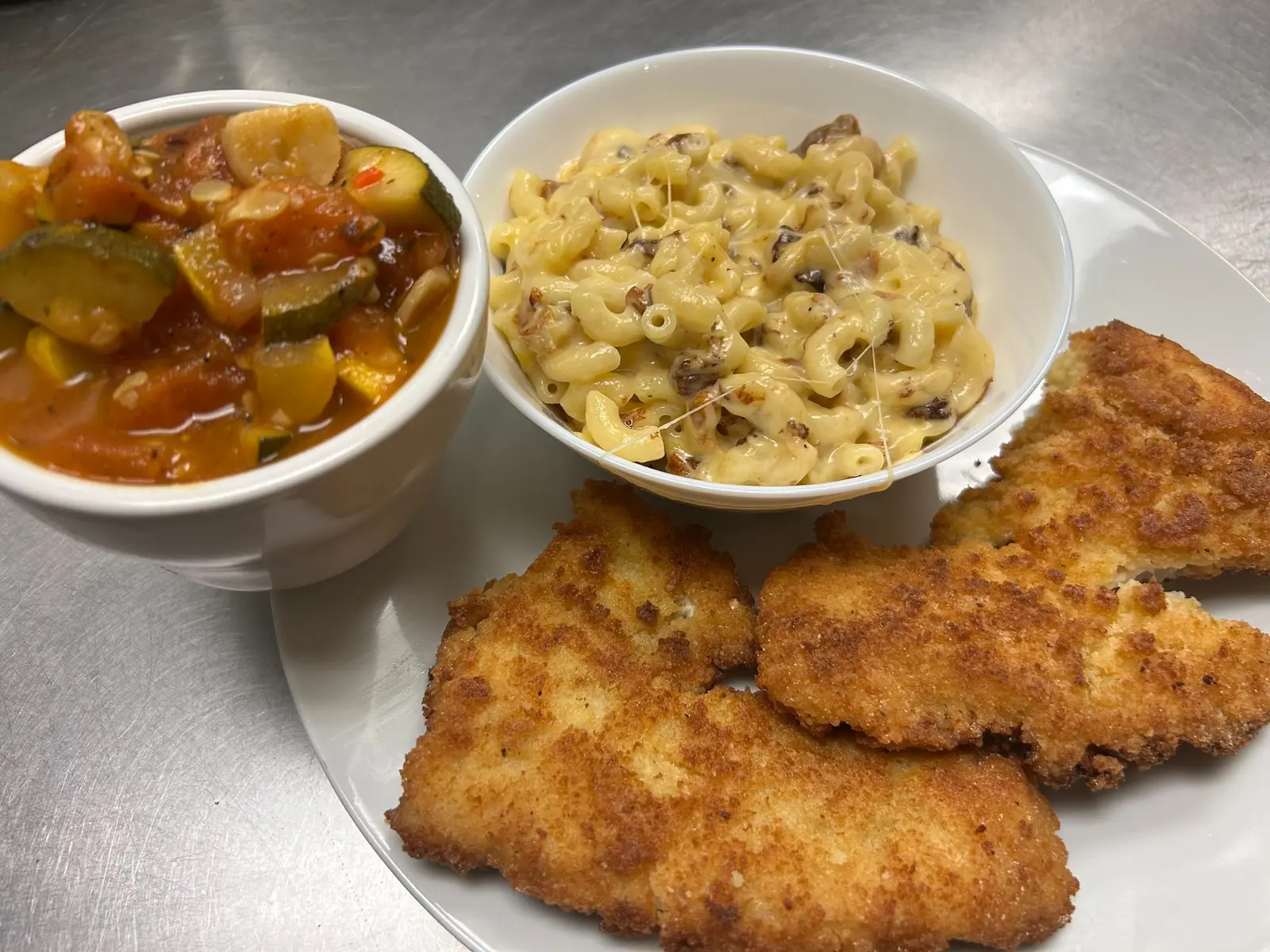 Golden pan-fried fish fillets served with creamy mac and cheese and stewed vegetables at Kat’s Café & Restaurant.