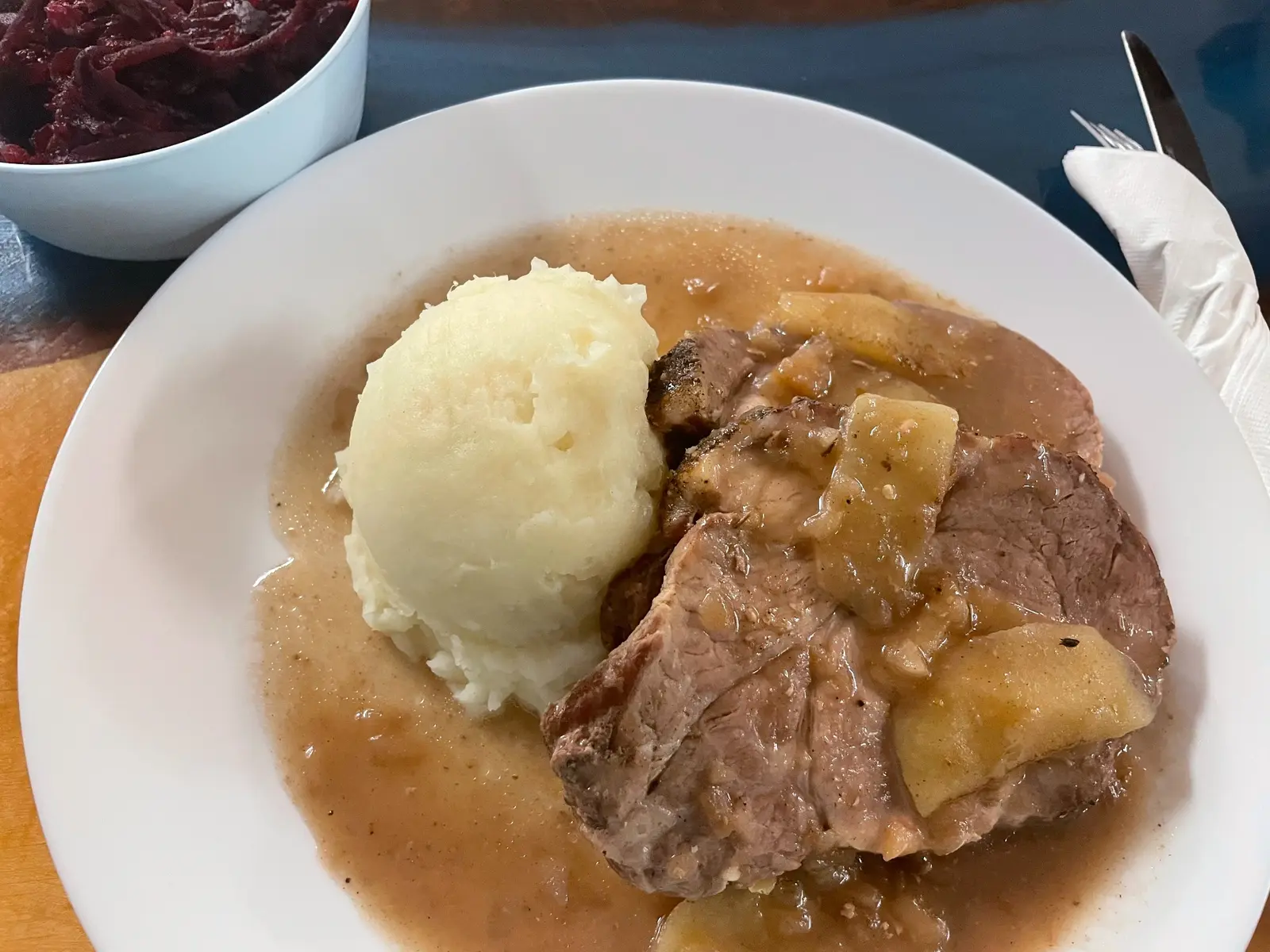 Apple pork roast with light natural gravy and fruit pieces, served with homemade mashed potatoes and a Slavic vegetable salad at Kat’s Café & Restaurant.