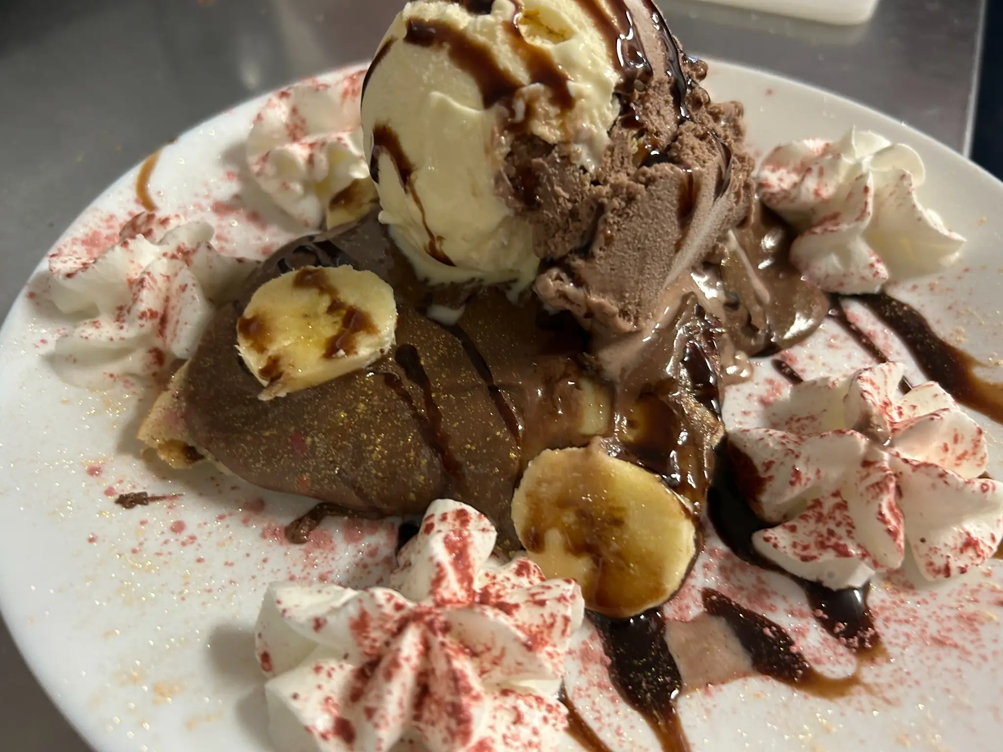 Banana split-style sweet cheese blintz served with vanilla and chocolate ice cream, banana slices, whipped cream, and chocolate sauce at Kat’s Café & Restaurant.