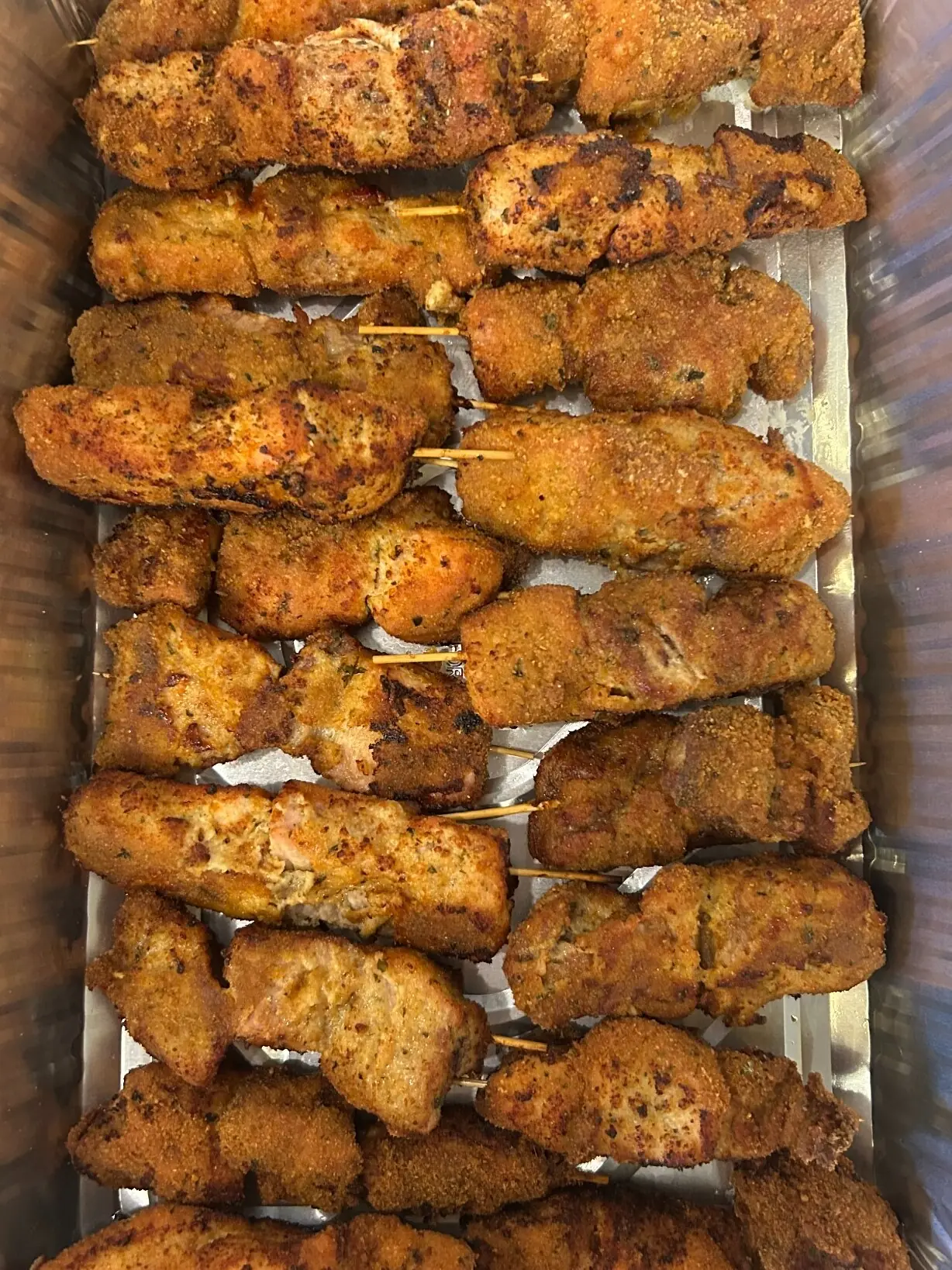 Overhead view of a large catering tray filled with golden-brown chunk-style City Chicken skewers from Kat’s Café & Restaurant.
