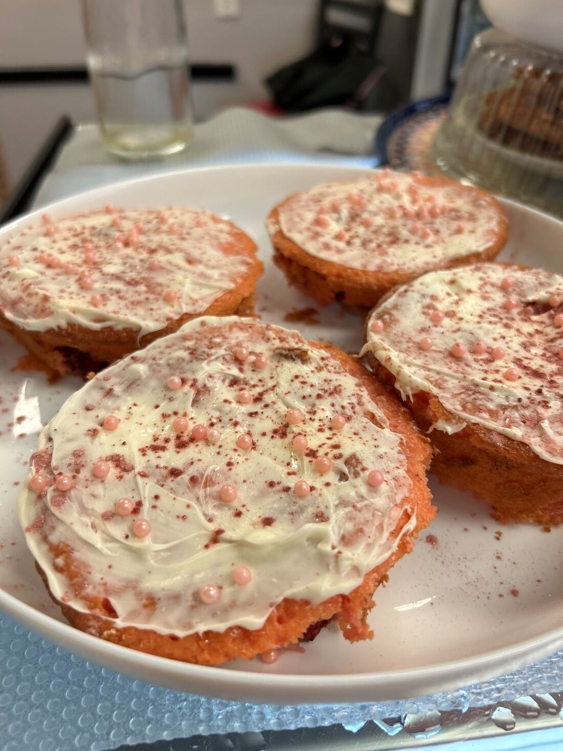 Strawberry Banana Mini Cakes with Frosting Smear and Sugar Pearls served on a clean white plate.