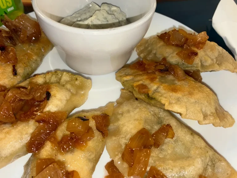 Spinach and feta cheese pierogies topped with caramelized onions and served with creamy artichoke dip at Kat’s Café & Restaurant.