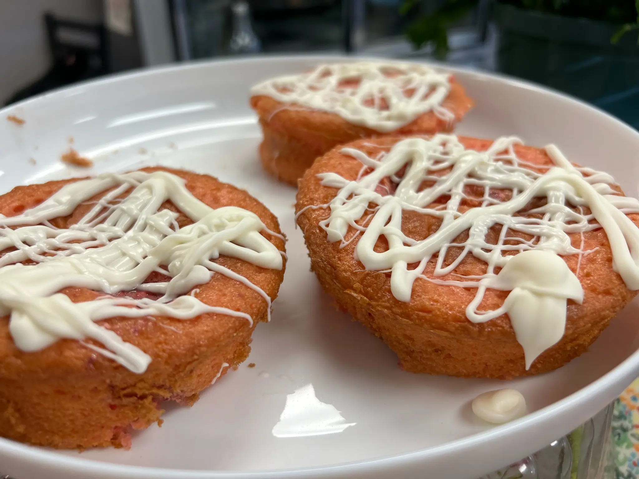 Three strawberry banana mini cakes topped with white frosting and arranged on a plate at Kat’s Café & Restaurant.