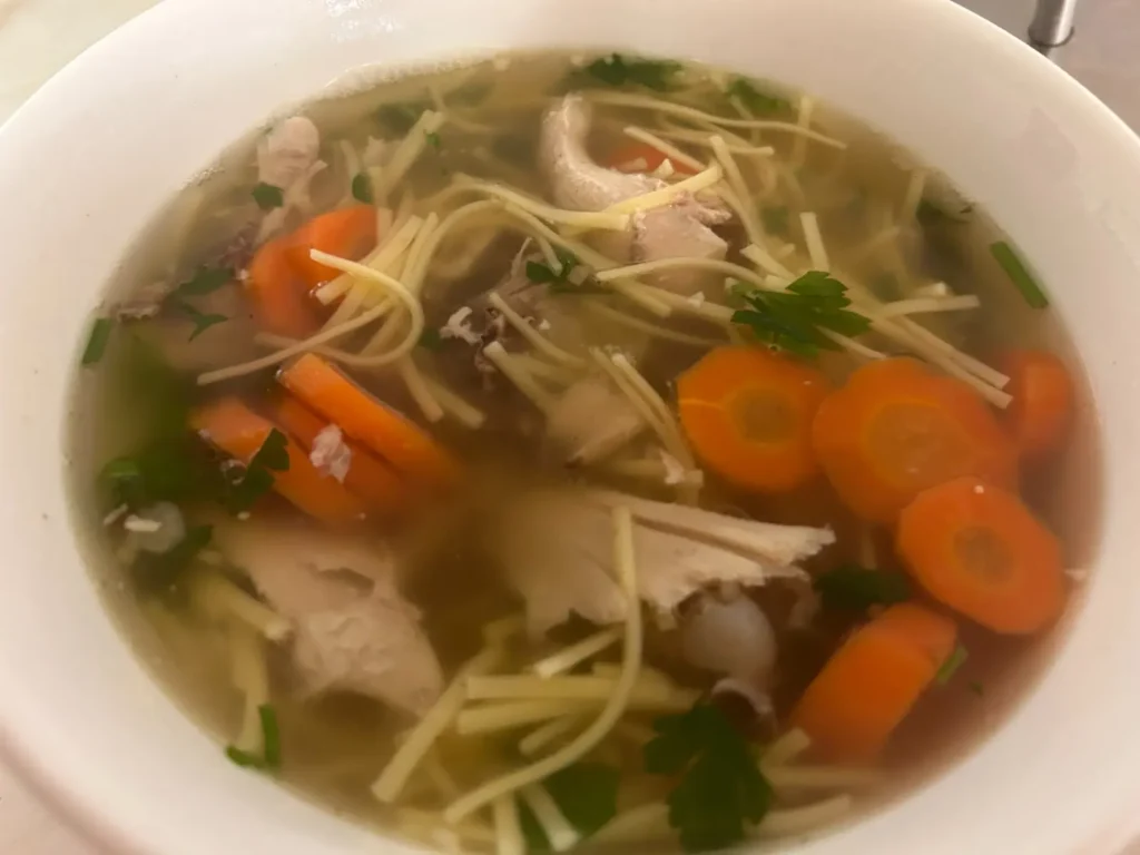 Bowl of Kat’s country-style chicken soup made with homemade broth, tender chicken, carrots, thin noodles, and fresh parsley at Kat’s Café & Restaurant.