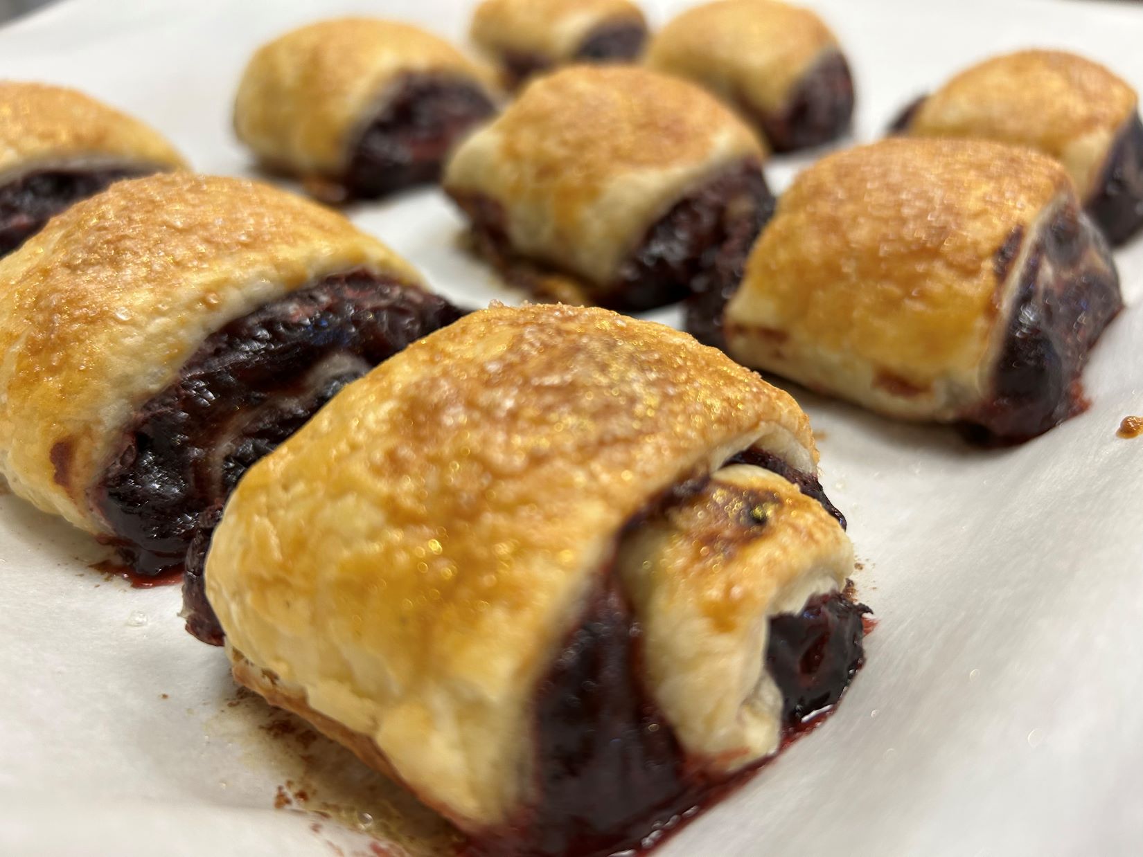 A photo of Cranberry Marmalade Croissants laid out on wax paper, close up.