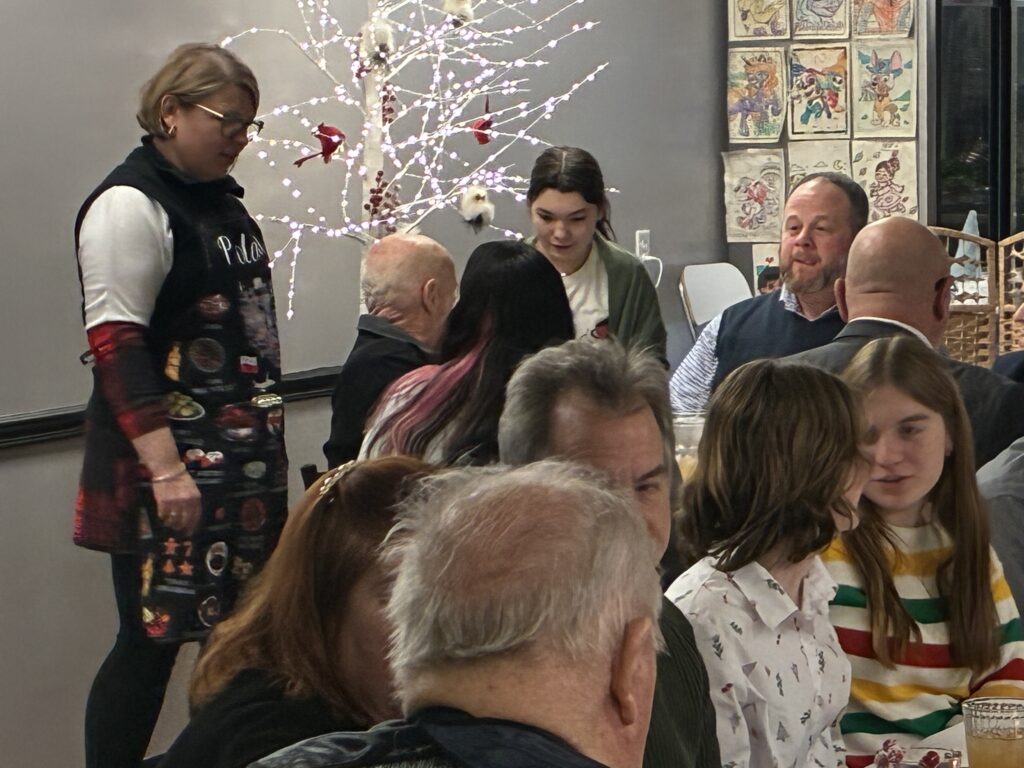 Kat's 2nd Annual Christmas Eve Holy Supper Event Photo with Chef Kat engaging with customers.