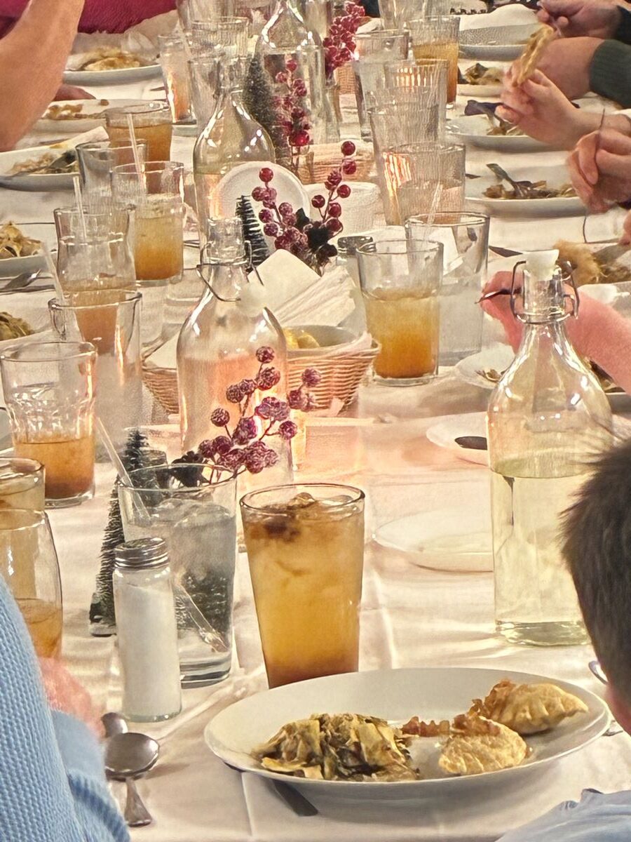 Christmas Eve Holy Supper Vigil Feast on an Adorned Table with a White Tablecloth, Christmas decorations, and plates of food.