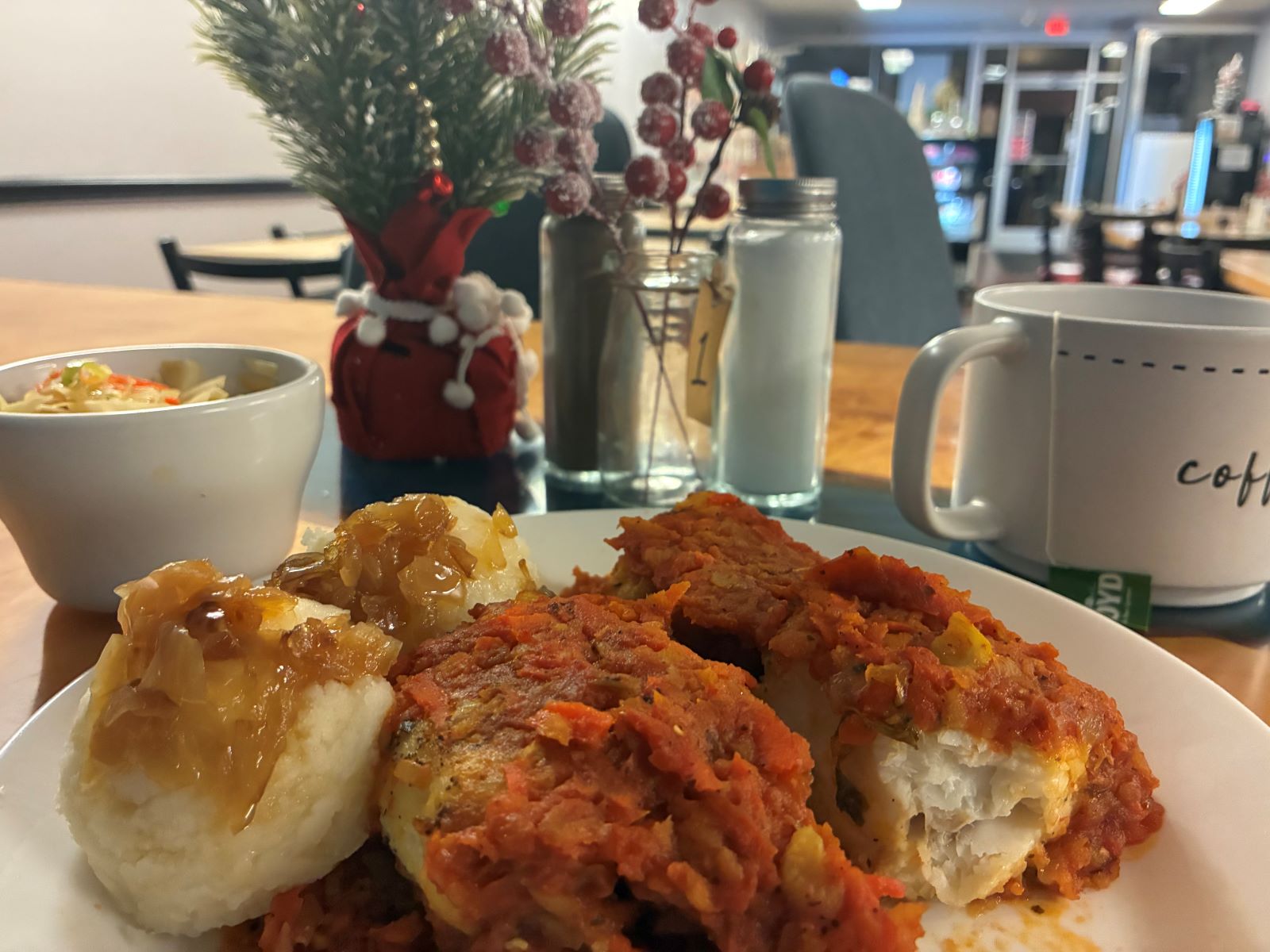 A photo of ryba po Gretcku or Greek style fish at Kat's Cafe and Restaurant with the entire length of the restaurant in the background all the way to the front window display and entrance.