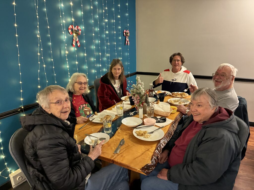 A group of merry individuals enjoying delicious food and laughter at Kat's.