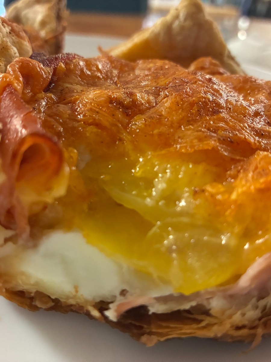 Ham, egg, and cheese croissant cut in half on a plate at Kat’s Café & Restaurant.