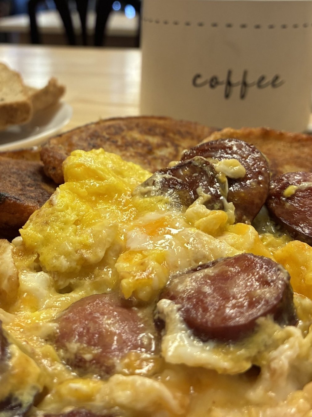 Freshly cooked breakfast with scrambled eggs, kielbasa, and pan-fried bleenies, served with toast and coffee at Kat’s Café & Restaurant.