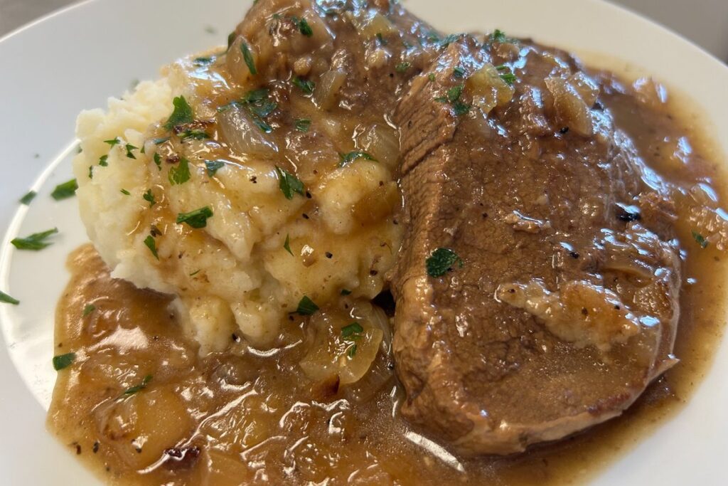 Beef in French onion gravy with mashed potatoes, topped with caramelized onions and herbs at Kat’s Café & Restaurant.