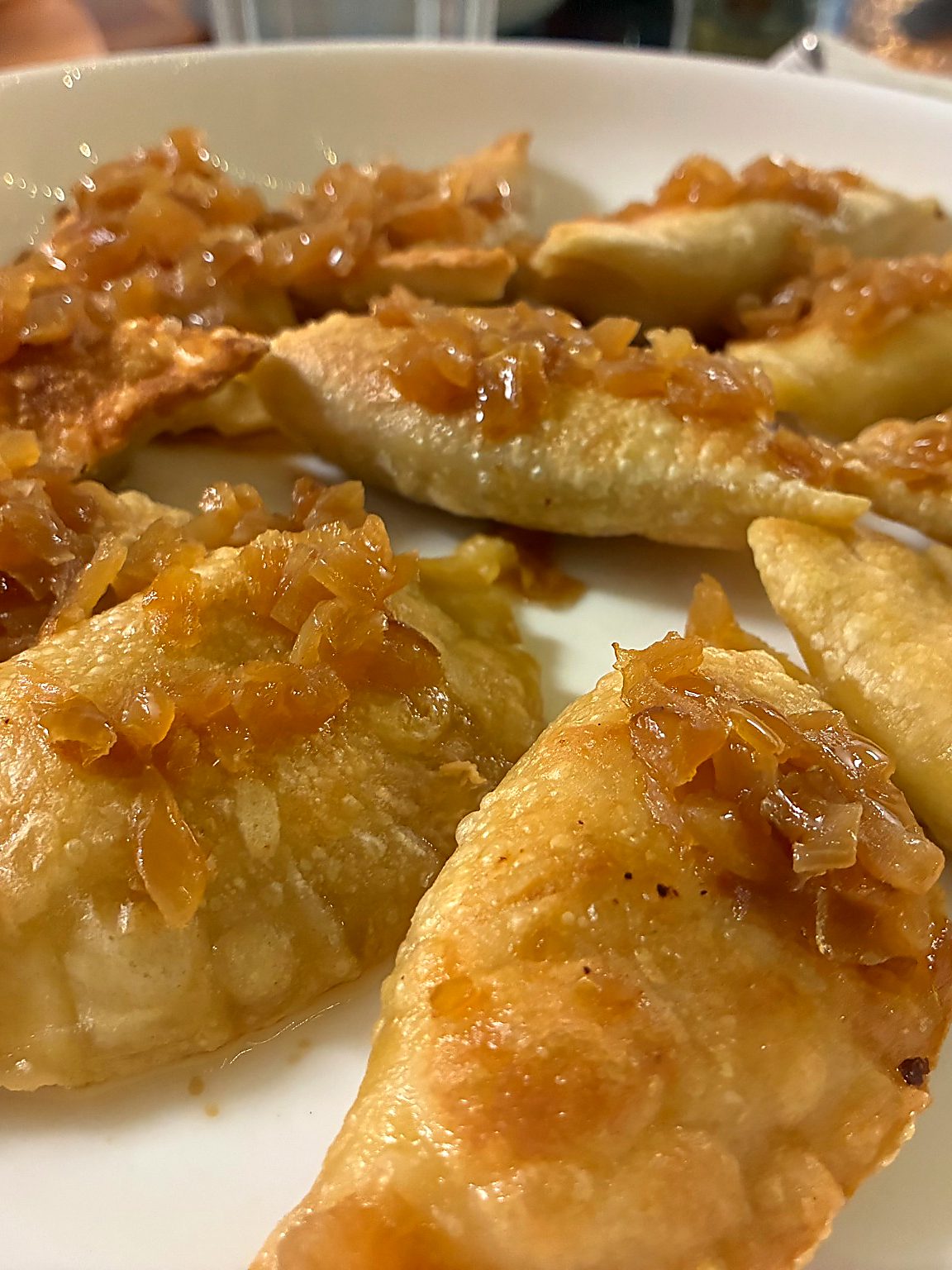 Large handmade pierogies topped with caramelized onions served on a white plate at Kat’s Café & Restaurant.