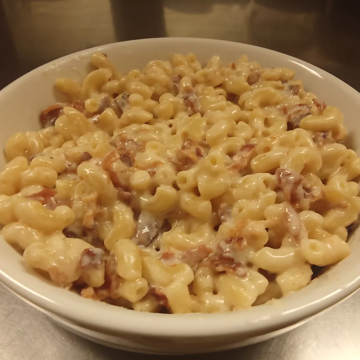 Bowl of homemade creamy macaroni and cheese in a white bowl.