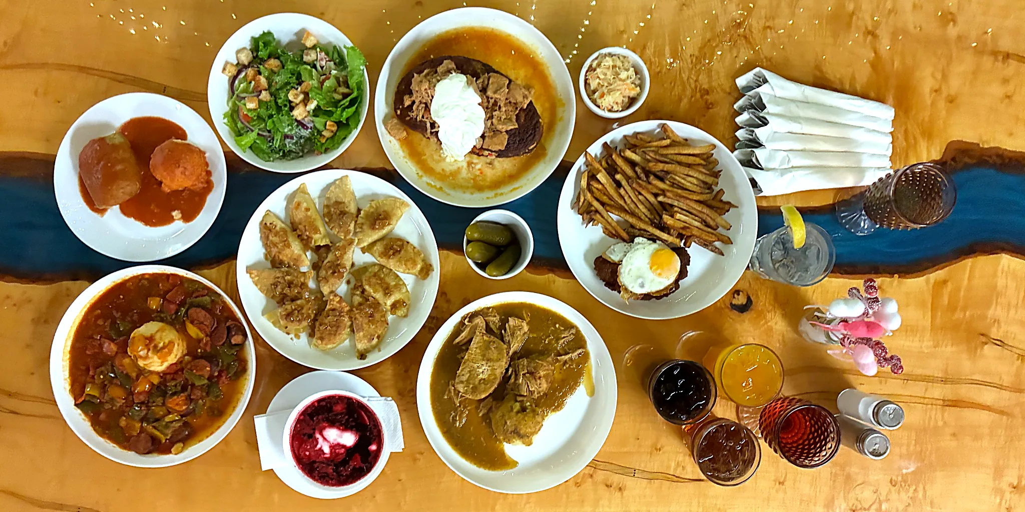 Overhead view of a table filled with Kat’s homestyle dishes including pierogies, borscht, salad, and a chicken cutlet with fries