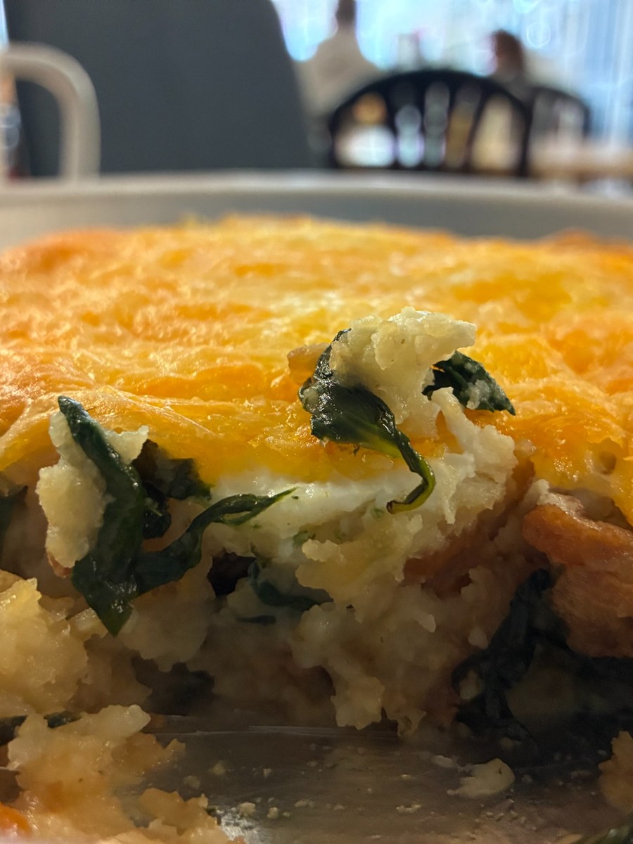 Potato, bacon, fried egg, and cheese deep-dish breakfast on a plate at Kat’s Café & Restaurant.