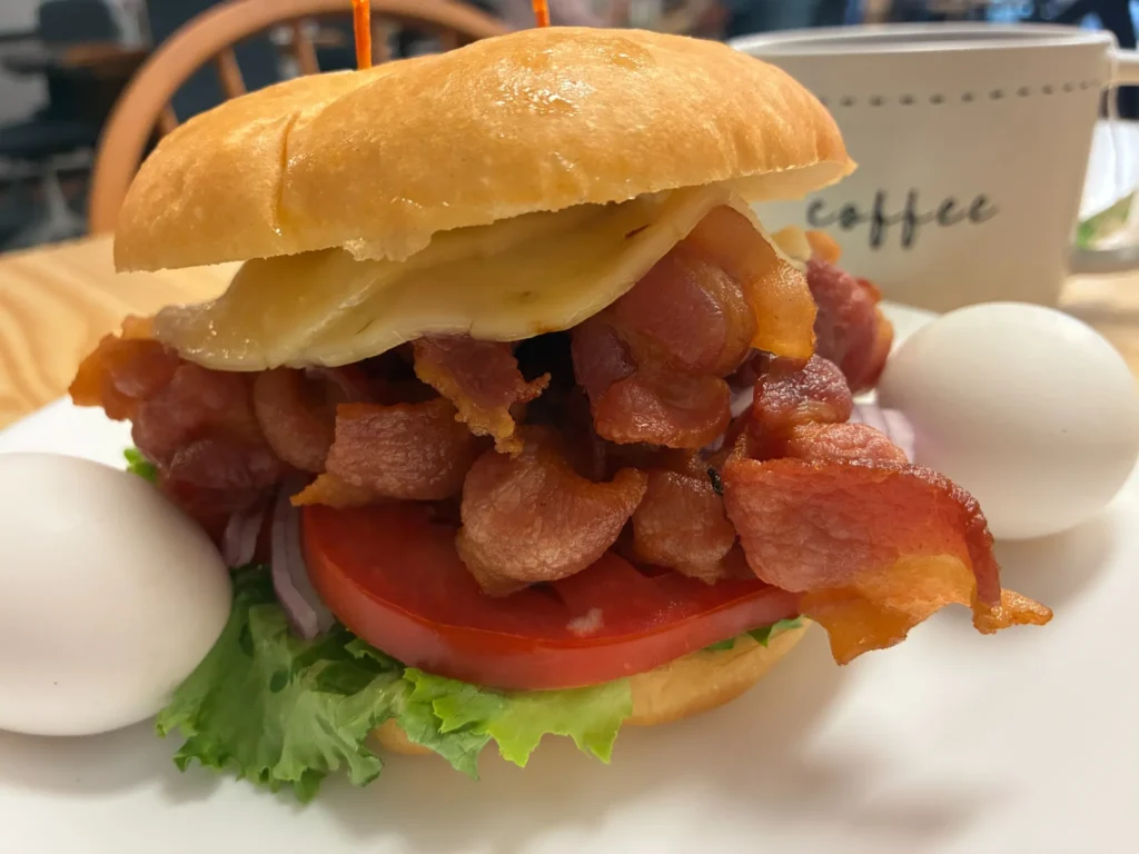 BLT sandwich on a fresh roll with bacon, lettuce, tomato and cheese.