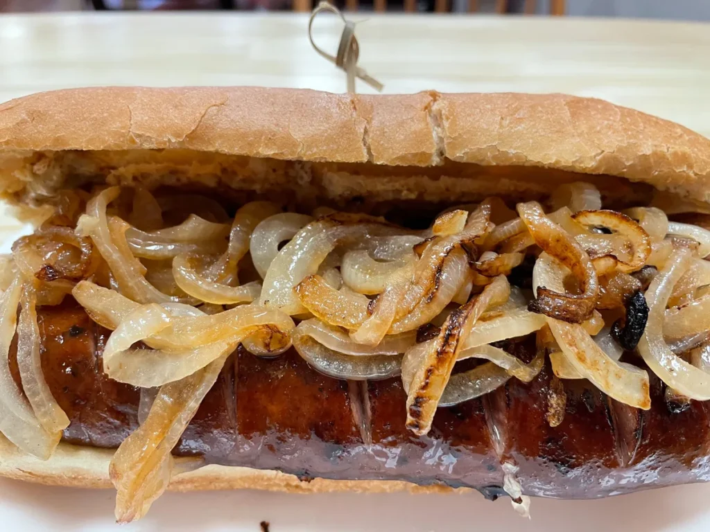 Kielbasa and onions sub on a long hoagie roll with a grilled Polish kielbasa link topped with sautéed onions.
