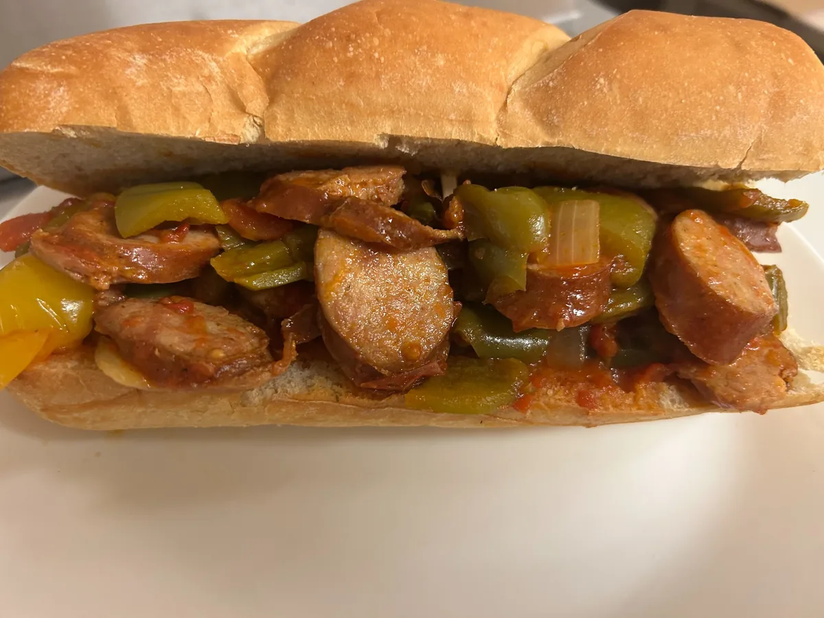 Letcho kielbasa sub on a long hoagie roll with sliced kielbasa, bell peppers, onions, and stewed tomatoes.