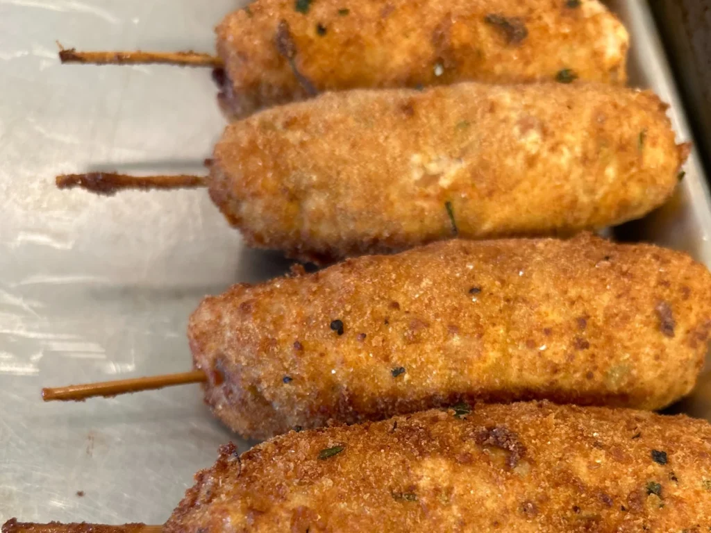 Breaded city chicken skewers lined up on a sheet pan at Kat’s Café & Restaurant.