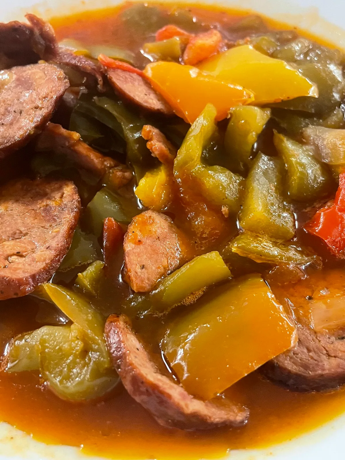 Sliced kielbasa sausage with peppers and onions in letcho sauce.