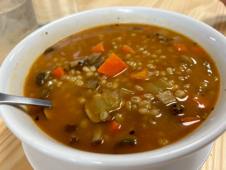 Mushroom barley soup with barley, carrots, onions, and mushrooms in a rich brown broth.
