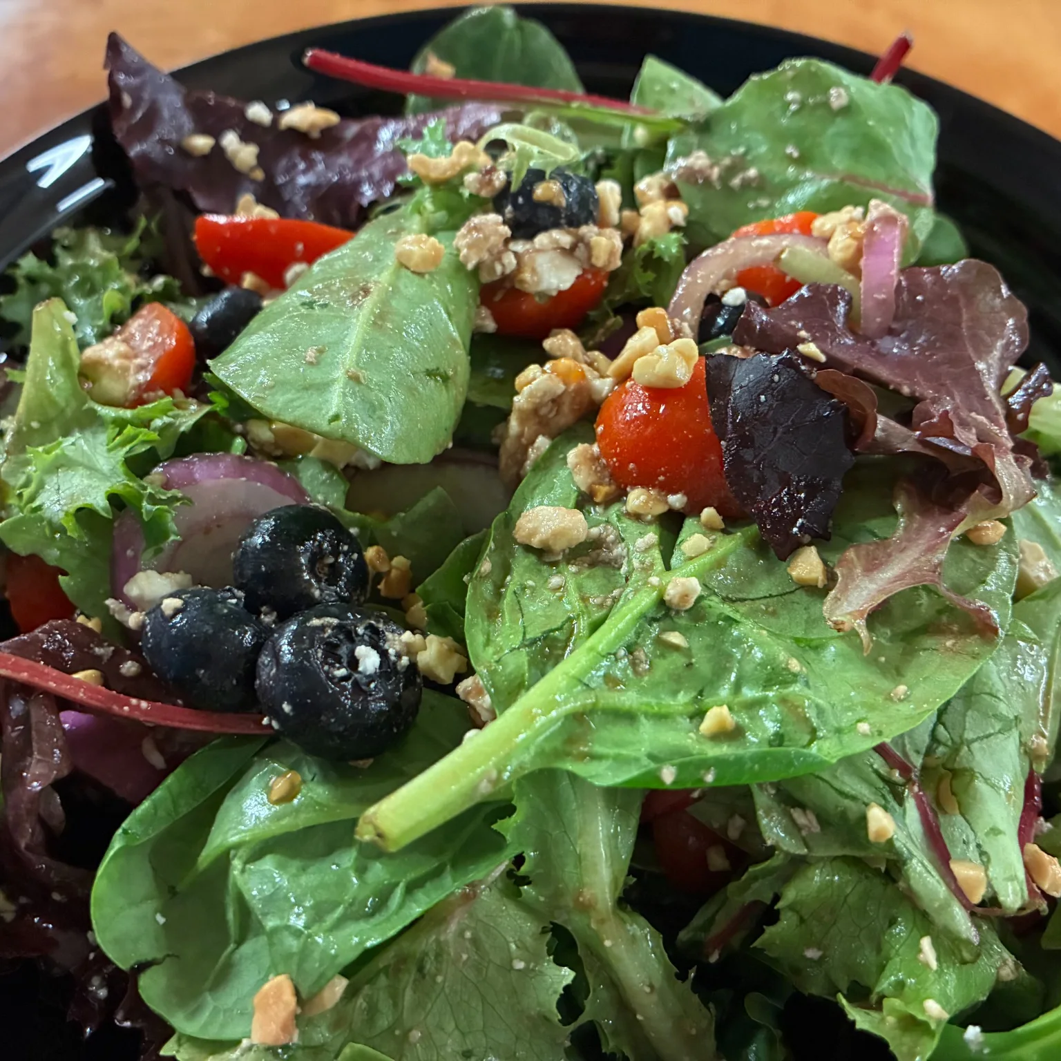 Mixed green house salad with berries, blueberries, red onion and crunchy nut topping.