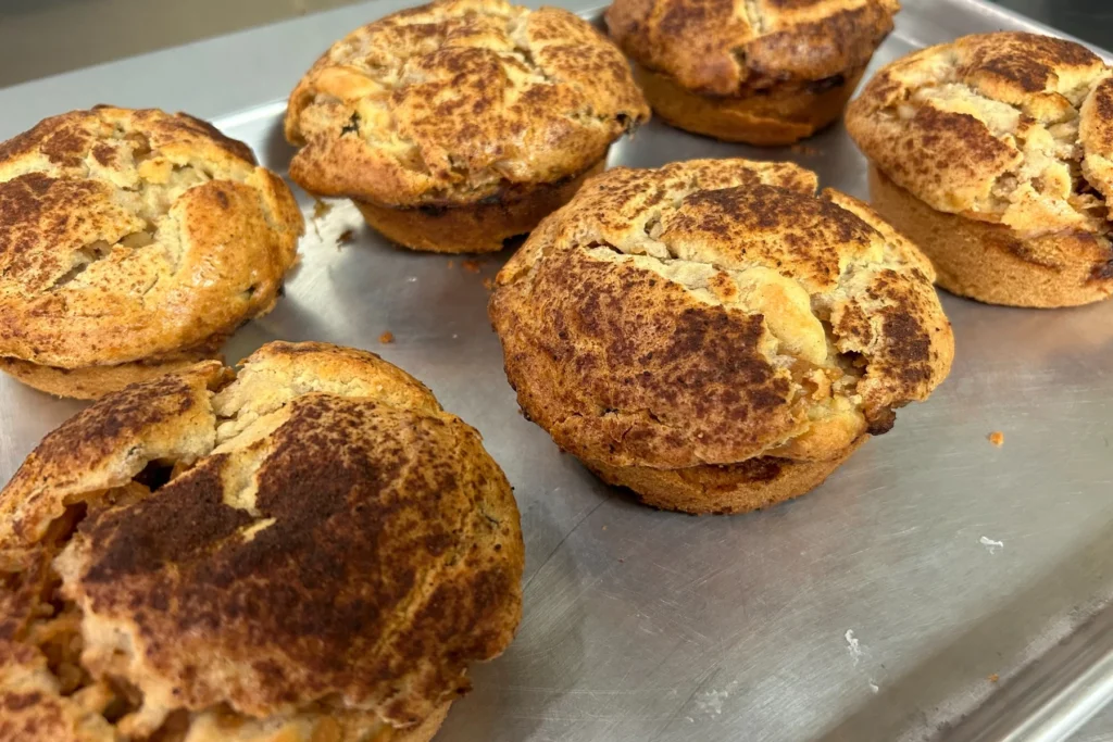 Apple cinnamon mini cakes baked in individual portions with a golden top and a generous cinnamon dusting.