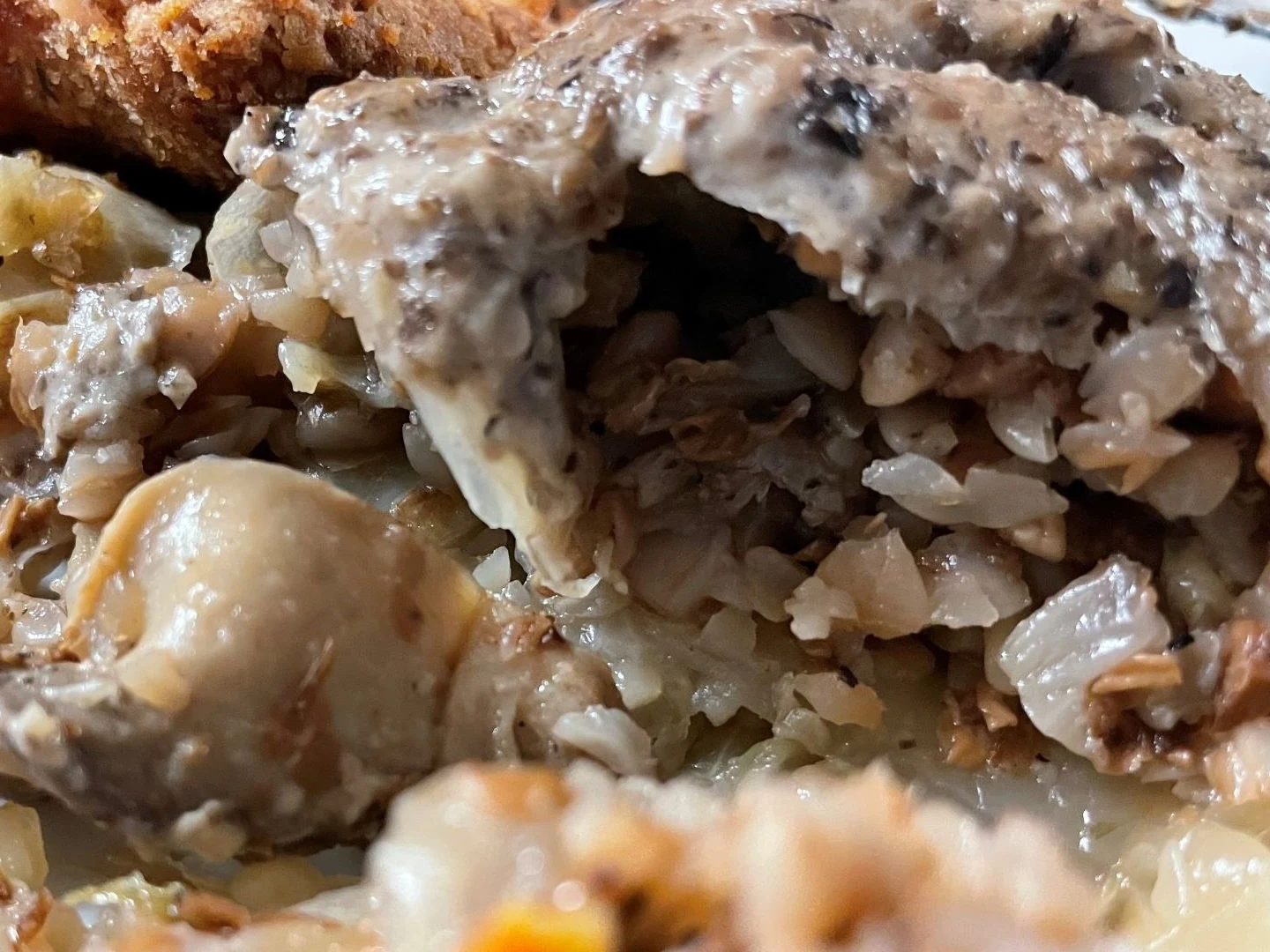 Close-up of Kat's buckwheat mushroom halupki showing the hearty filling under creamy mushroom sauce.