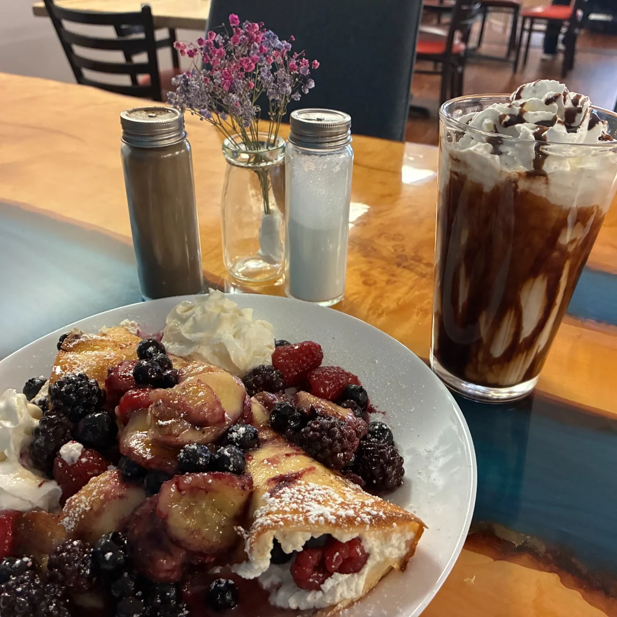 Fruit blintz with berries and whipped cream served with an iced mocha coffee at Kat's Café & Restaurant.