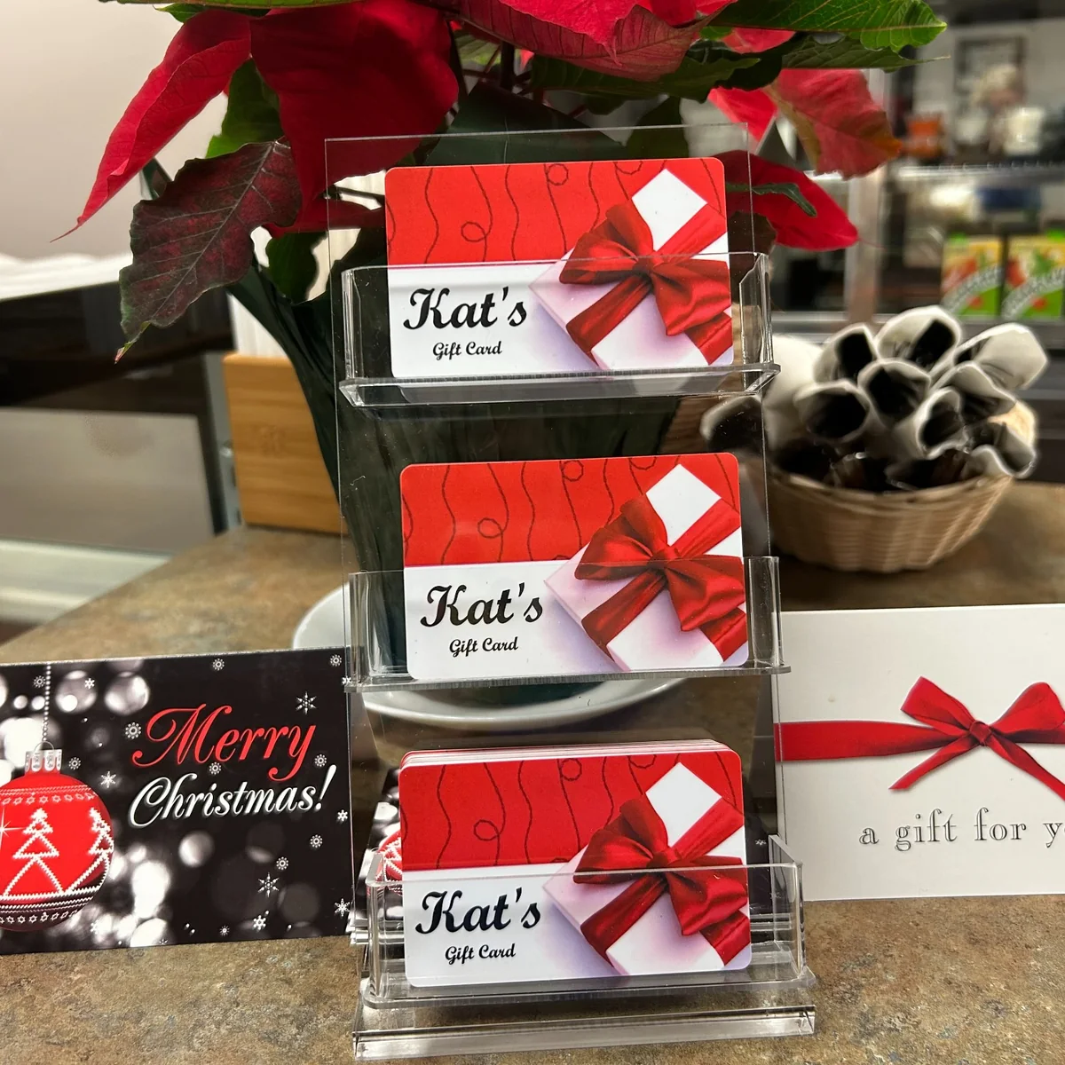 Kat’s Café & Restaurant gift cards displayed with Christmas and gift-for-you cards at the restaurant.
