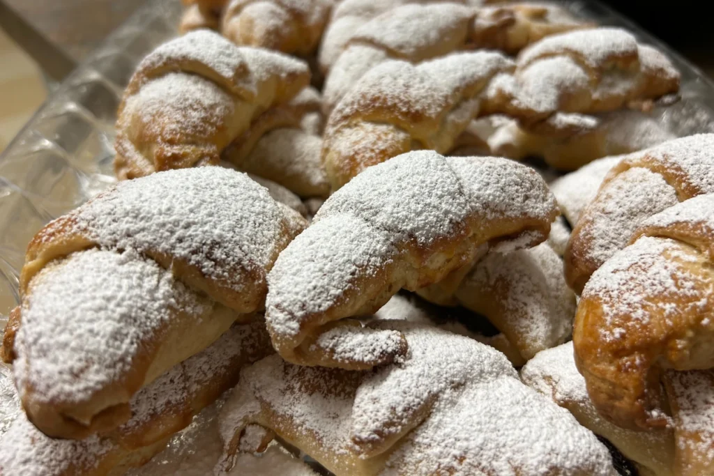 Golden croissants dusted with powdered sugar and filled with plum butter.