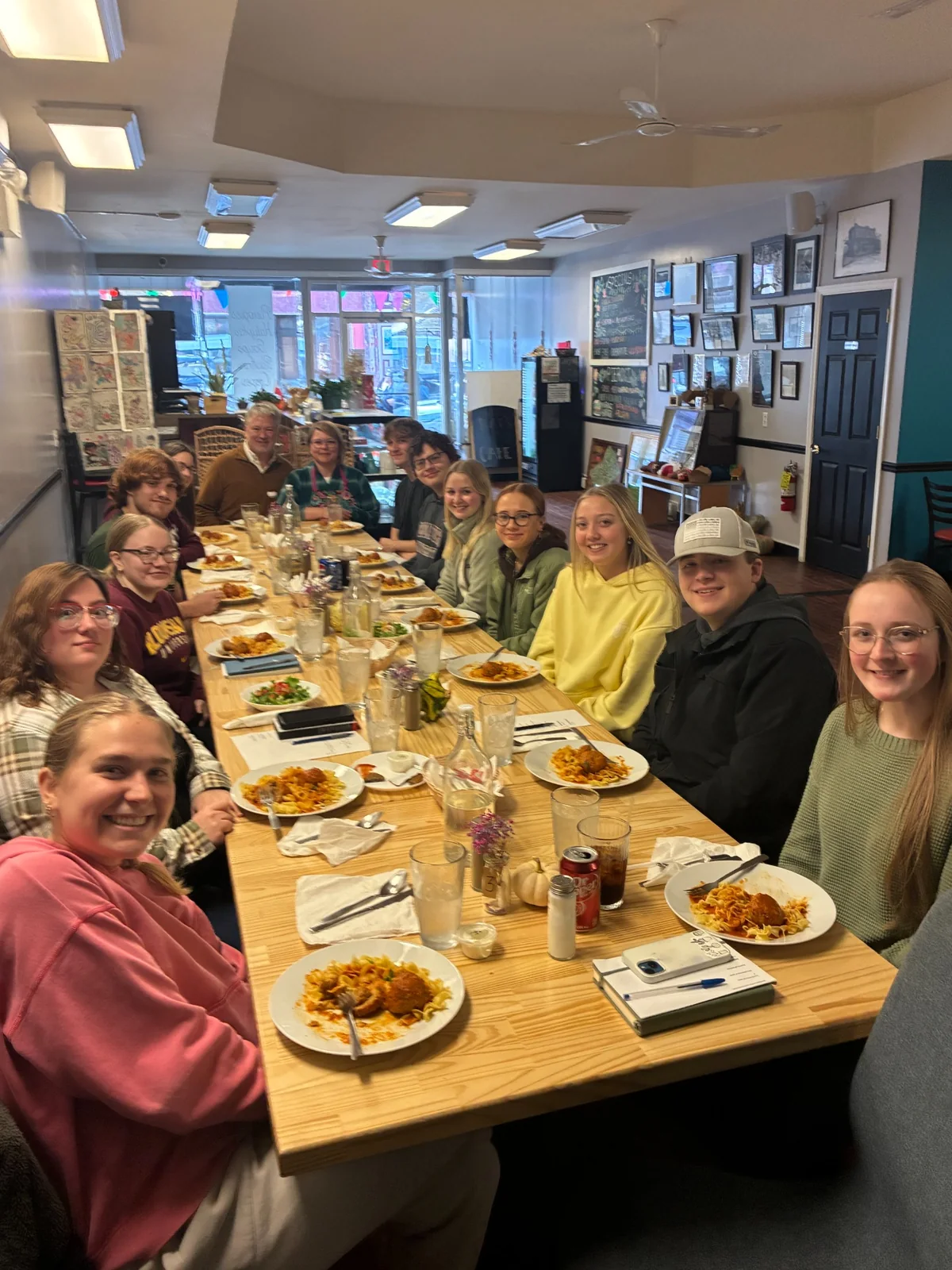 A group of guests smiling around a long table during a private dinner at Kat's Café & Restaurant.