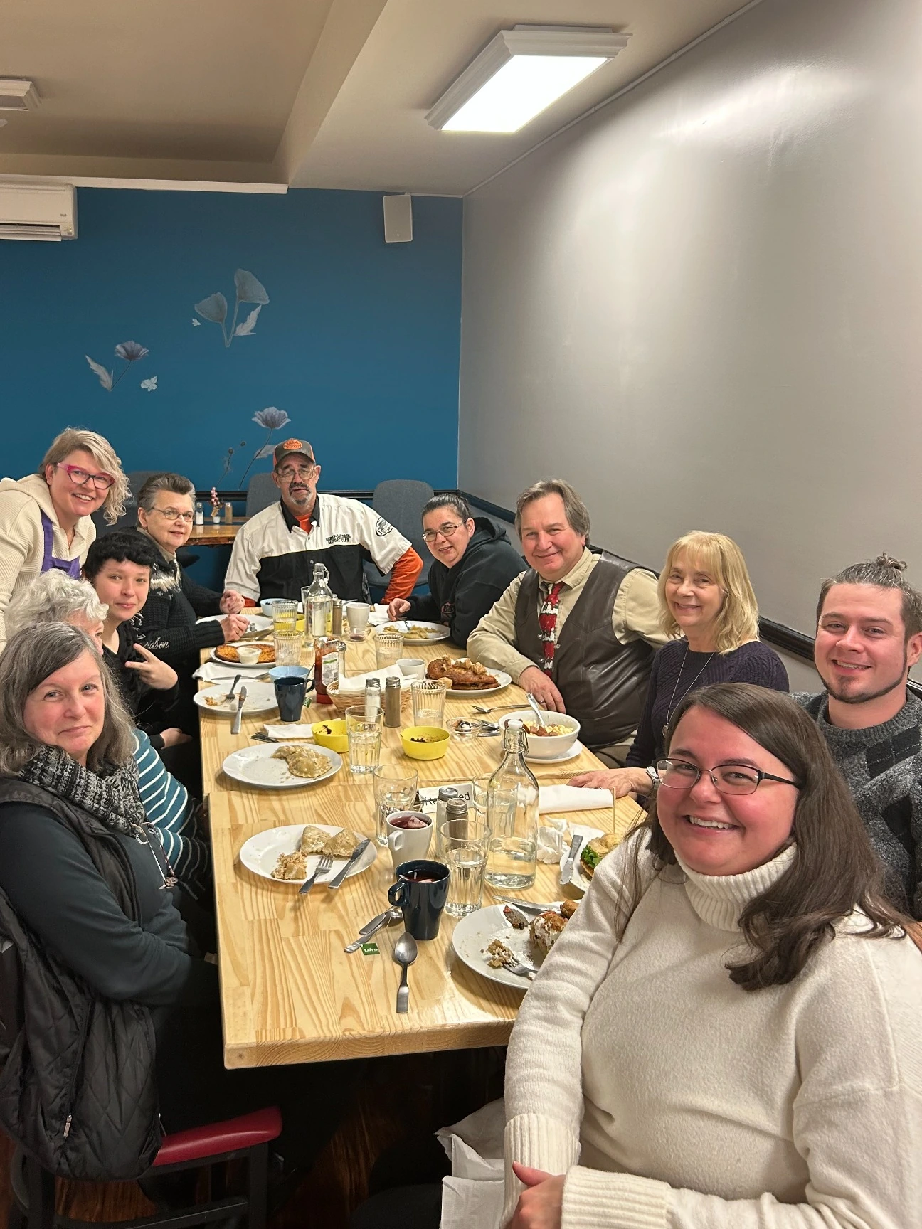 Guests smiling around a shared table during a private celebration dinner at Kat's Café & Restaurant.