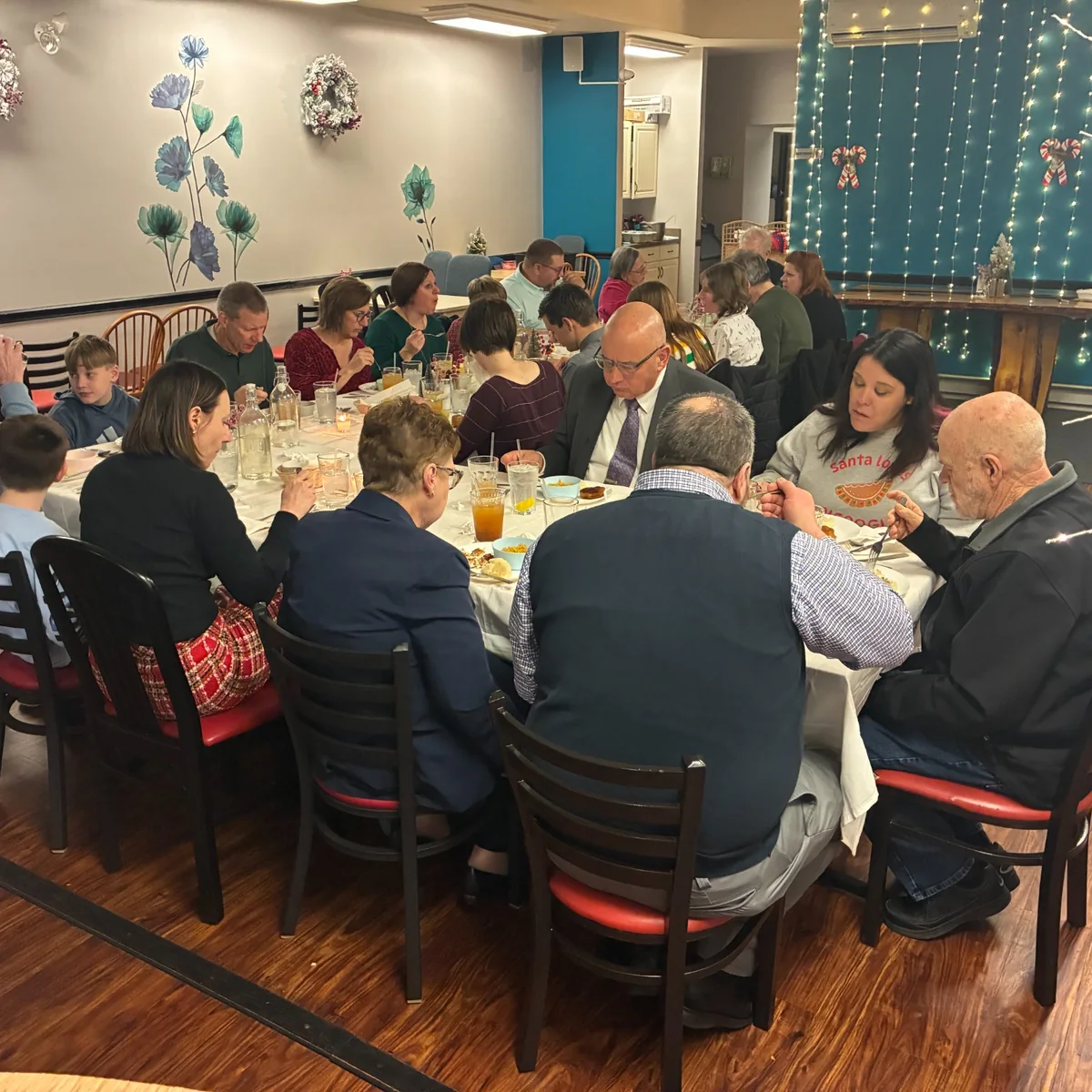 Guests seated around a large table during a private family-style dinner in Kat's event space.
