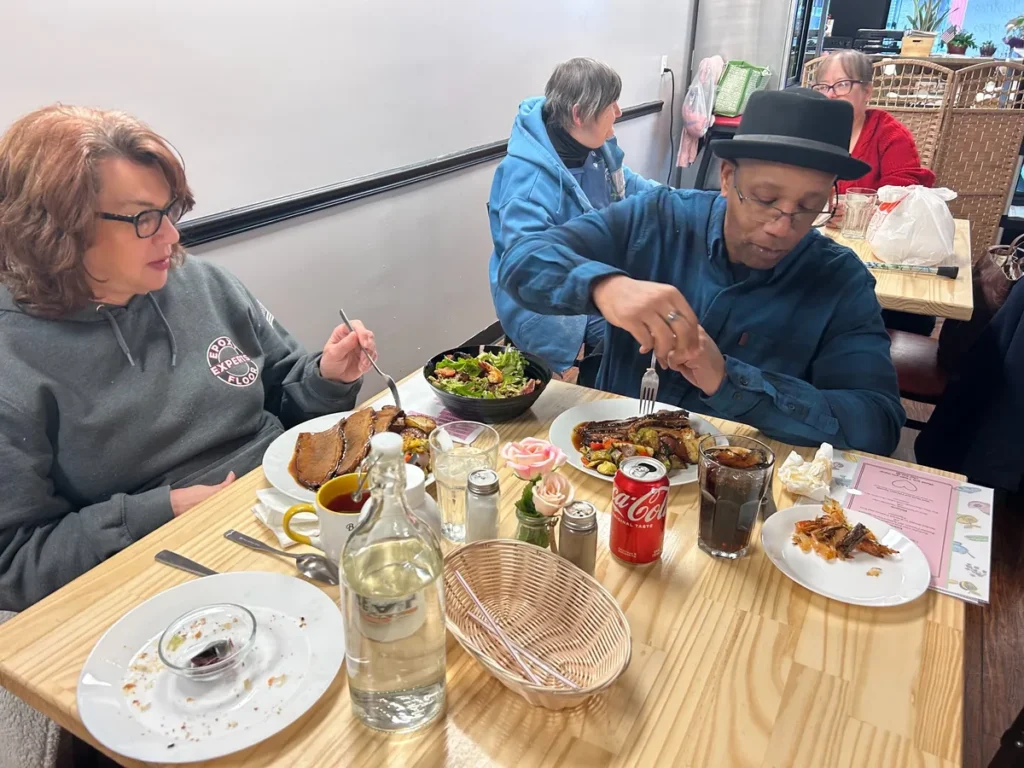 Guests enjoying plated comfort food and salad at a table at Kat’s Café & Restaurant