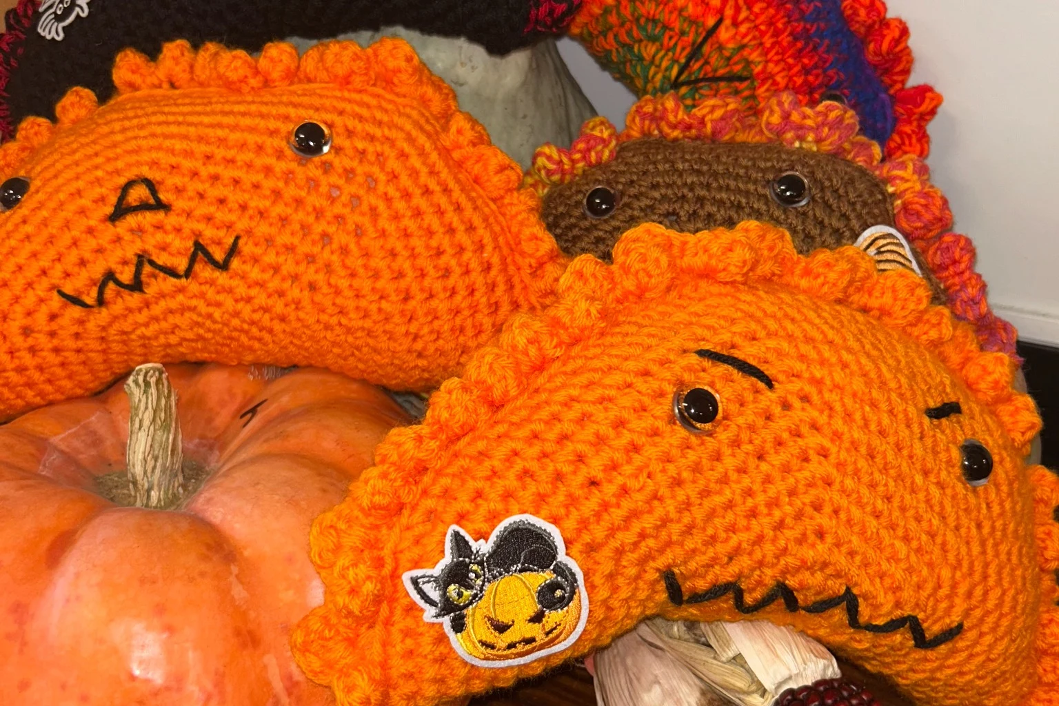 Fall Halloween crochet pierogi display at Kat’s Handmade Halloween crochet pierogi pillows displayed with pumpkins and decorative corn at Kat’s Café & Restaurant.